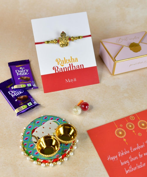 Sowpeace Exquisite Golden Ganesha Rakhi Pack of 1 with Roli Chawal Thali, Chocolates, and Greeting card combo for Raksha Bandhan and Gifting
