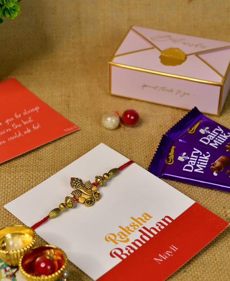 Sowpeace Exquisite Golden Ganesha Rakhi Pack of 1 with Roli Chawal Thali, Chocolates, and Greeting card combo for Raksha Bandhan and Gifting