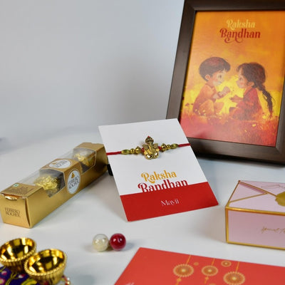 Sowpeace Exquisite Golden Ganesha Rakhi Pack of 1 with Roli Chawal Thali, Chocolates, Photo Frame and Greeting card combo for Raksha Bandhan and Gifting