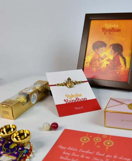 Sowpeace Exquisite Golden Ganesha Rakhi Pack of 1 with Roli Chawal Thali, Chocolates, Photo Frame and Greeting card combo for Raksha Bandhan and Gifting