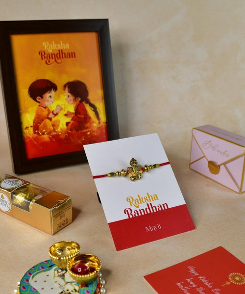 Sowpeace Exquisite Golden Ganesha Rakhi Pack of 1 with Roli Chawal Thali, Chocolates, Photo Frame and Greeting card combo for Raksha Bandhan and Gifting