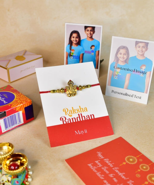 Sowpeace Exquisite Golden Ganesha Rakhi Pack of 1 with Roli Chawal Thali, Chocolates, Poloroids and Greeting card combo for Raksha Bandhan and Gifting